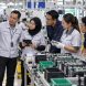 Malaysian manufacturing team reviewing a Kaizen improvement process on the shop floor